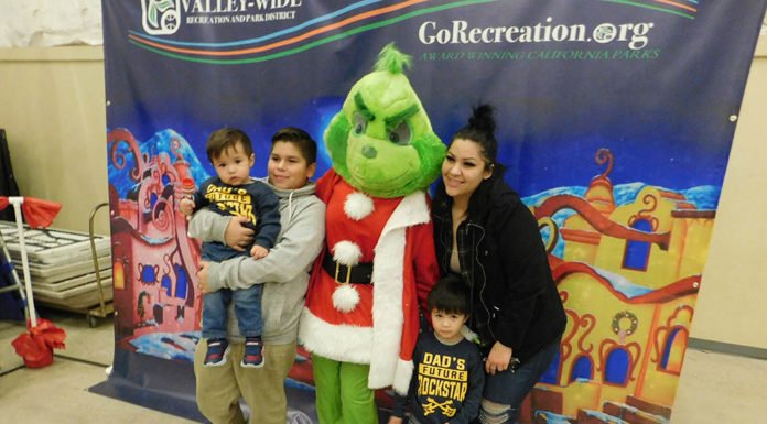 The Grinch helps children find green presents in Winchester’s Francis Domenigoni Community Center