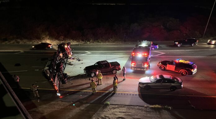 Truck with 5th wheel hauling cars flips over onto I-15 from ramp causing major delays