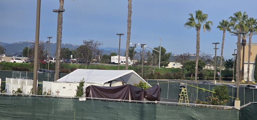 Heavily obsured scene with minimal visibility of the burned battery, likely to contain HAZMAT and prevent secondary incidents from passing drivers.